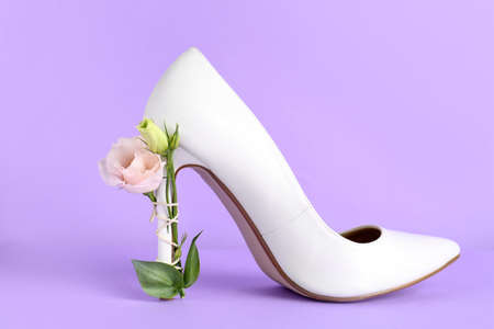 Stylish women's high heeled shoe with beautiful flower on violet backgroundの写真素材