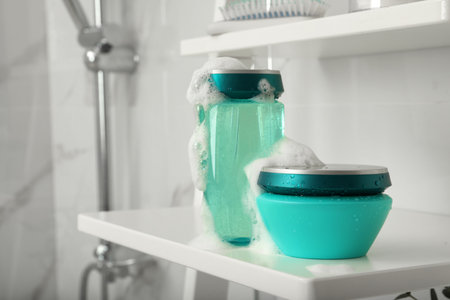 Hair care cosmetic products with foam on shelf indoors, space for textのeditorial素材