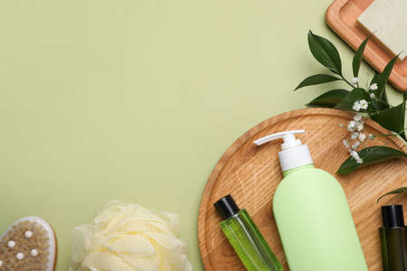 Flat lay composition with shower gel bottles on light green background, space for textの写真素材
