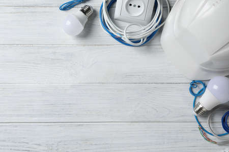 Set of electrician's accessories on white wooden background, space for textの写真素材