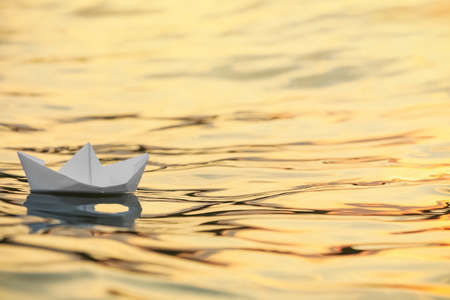 Paper boat floating on water outdoors. Space for textの写真素材