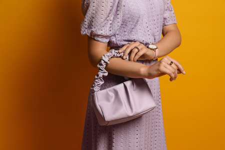 Fashionable woman with stylish bag on orange background, closeupの写真素材