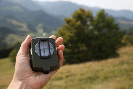 Woman using compass for navigation during journey in mountains, closeupの写真素材