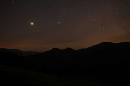 Picturesque view of mountain landscape and beautiful starry sky at nightの写真素材