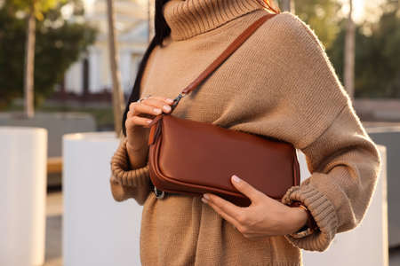 Fashionable woman with stylish bag on city street, closeupの写真素材