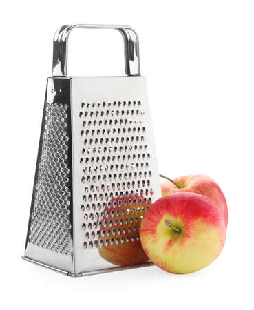 Stainless steel grater and fresh apples on white backgroundの写真素材