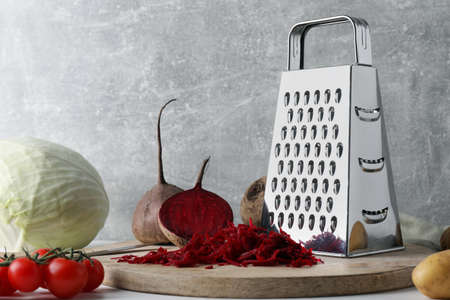 Grater and fresh ripe vegetables on tableの写真素材