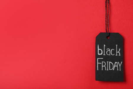 Black Friday tag on red background, space for textの写真素材