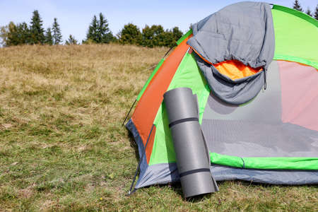 Grey sleeping bag on camping tent and mat outdoors, space for textの写真素材