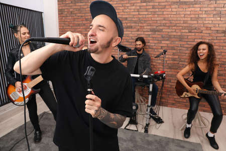 Music band performing in modern recording studioの写真素材