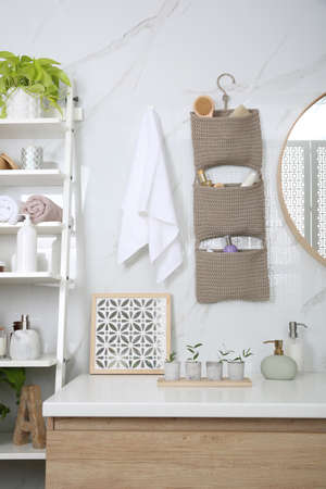 Knitted organizer hanging on wall in bathroomの写真素材