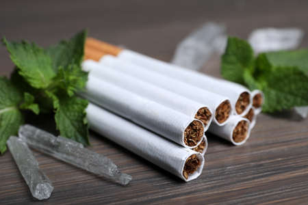 Cigarettes, menthol crystals and mint on wooden table, closeupの写真素材
