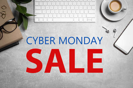 Cyber Monday Sale. Flat lay composition with computer keyboard and smartphone on gray tableの写真素材