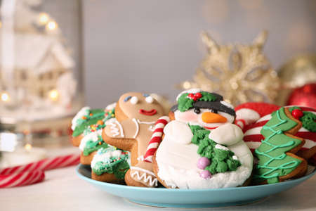 Sweet Christmas cookies on white table against blurred festive lights, closeupの写真素材