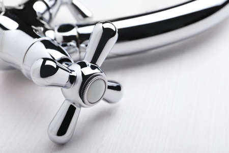 Double handle water tap on white wooden table, closeupの写真素材