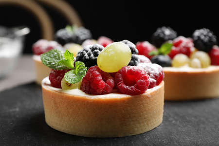 Delicious tartlets with berries on slate board, closeupの写真素材