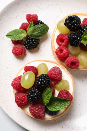 Delicious tartlets with berries on plate, top viewの写真素材