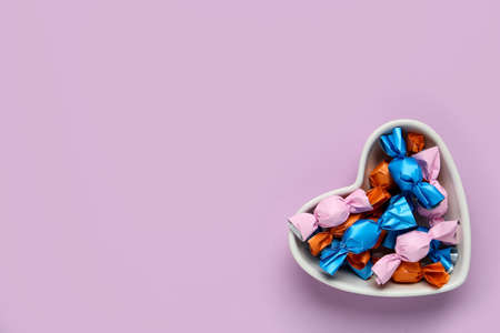Candies in colorful wrapper on pink background, top view. Space for textの写真素材