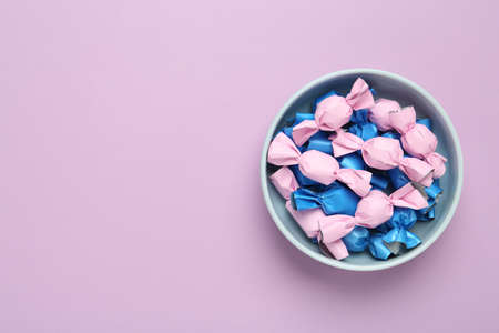 Candies in colorful wrapper on pink background, top view. Space for textの写真素材
