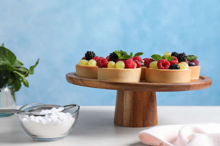 Delicious tartlets with berries on white tableの写真素材