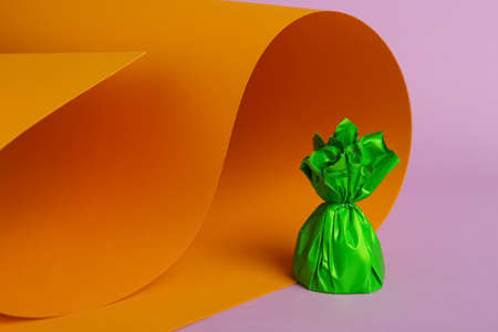 Candy in green wrapper on color background. Space for textの写真素材