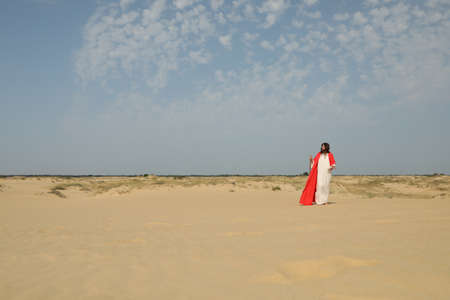 Jesus Christ walking with stick in desert. Space for textの写真素材