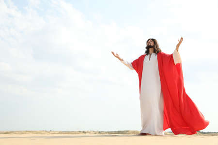 Jesus Christ raising hands in desert. Space for textの写真素材