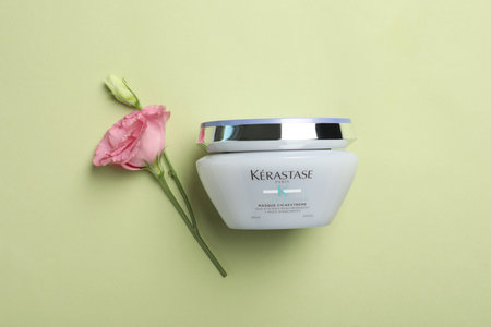 MYKOLAIV, UKRAINE - SEPTEMBER 07, 2021: Kerastase hair care mask and beautiful flower on light green background, flat layのeditorial素材
