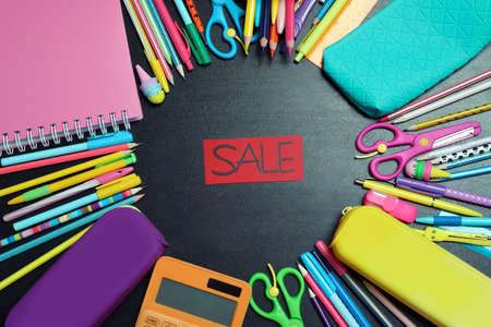Flat lay composition with school stationery and word Sale on blackboard