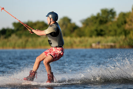 Teenage boy wakeboarding on river. Extreme water sportの写真素材