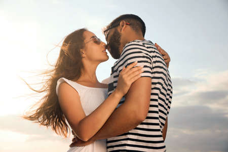 Lovely couple enjoying each other against sunny skyの写真素材