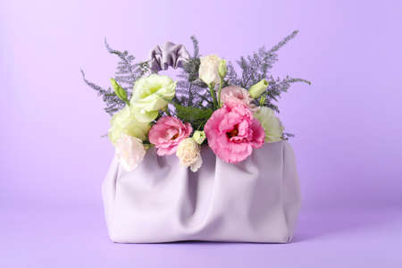 Stylish women's bag with beautiful flowers on violet backgroundの写真素材