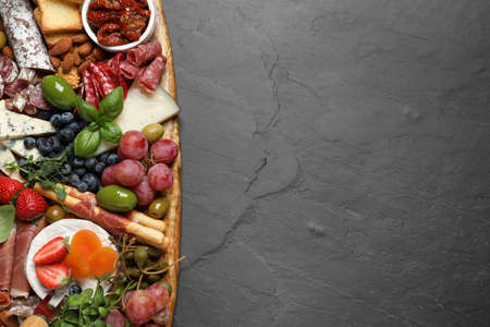 Set of different delicious appetizers served on black table, top view. Space for textの写真素材