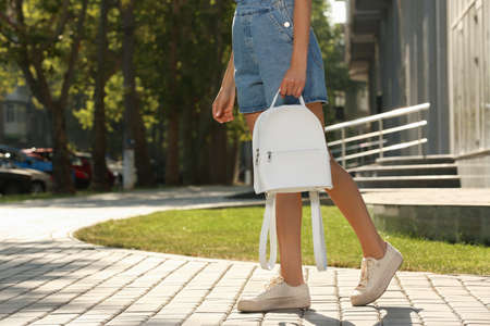 Young woman with stylish white backpack on city street, closeup. Space for textの写真素材