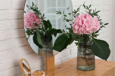 Beautiful pink hortensia flowers in vase on dressing table indoorsの写真素材