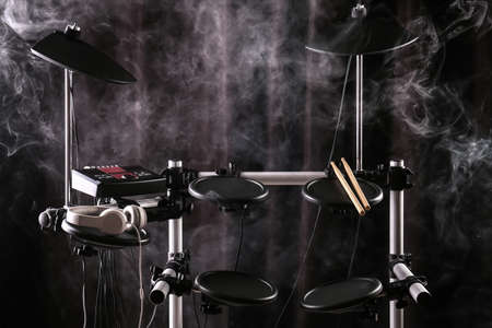 Modern electronic drum kit and smoke on dark background. Musical instrument