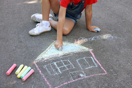 Little child drawing house with colorful chalk on asphalt, closeupの写真素材