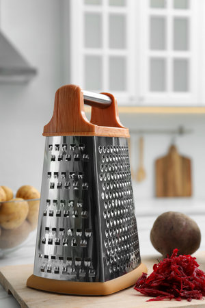 Grater and fresh ripe beetroot on table in kitchenの写真素材