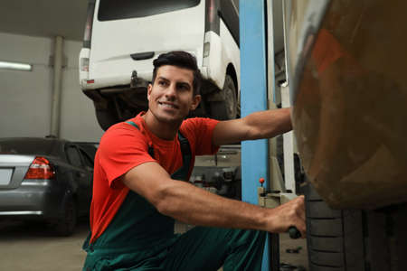 Professional mechanic changing wheel at automobile repair shopの写真素材