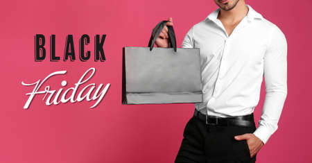 Black Friday Sale. Young man with shopping bag on pink background, banner designの写真素材