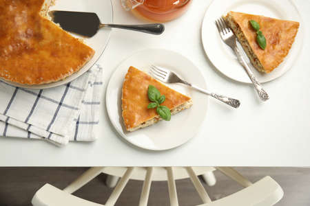 Delicious pie with meat and basil on white table, flat layの写真素材