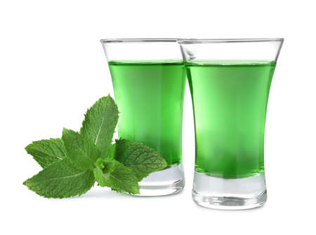 Delicious mint liqueur and fresh leaves on white backgroundの写真素材