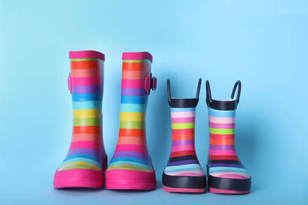 Two pairs of striped rubber boots on light blue backgroundの写真素材