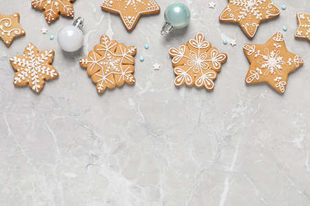 Tasty Christmas cookies and baubles on light gray marble table, flat lay. Space for text