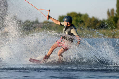 Teenage boy wakeboarding on river. Extreme water sportの写真素材