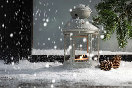 Snow falling onto window sill with Christmas lantern, outdoors. Space for textの写真素材