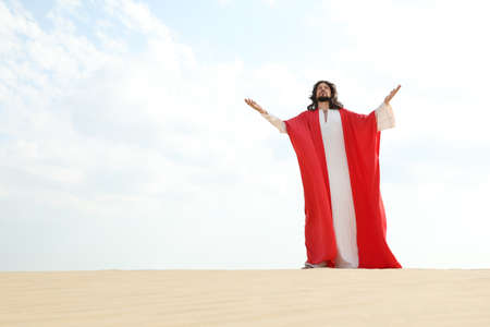 Jesus Christ raising hands in desert. Space for textの写真素材