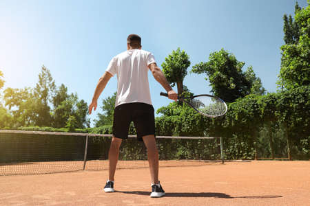 Man playing tennis on court, back viewの写真素材