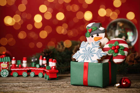 Sweet Christmas cookies and decor on wooden table against blurred festive lights. Space for textの写真素材