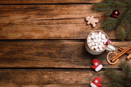 Flat lay composition of delicious hot chocolate with marshmallows and Christmas decor on wooden table, space for textの写真素材